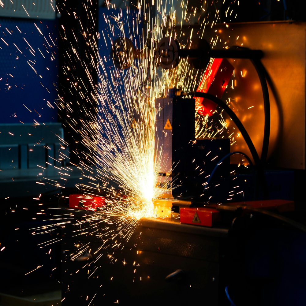 Processo di saldatura industriale con scintille e spruzzi di metallo fuso in ambiente di produzione