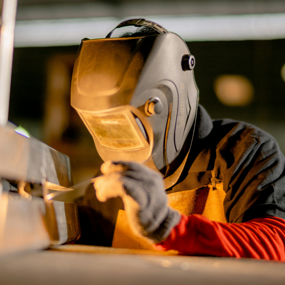 saldatore con maschera autoscurante durante saldatura TIG