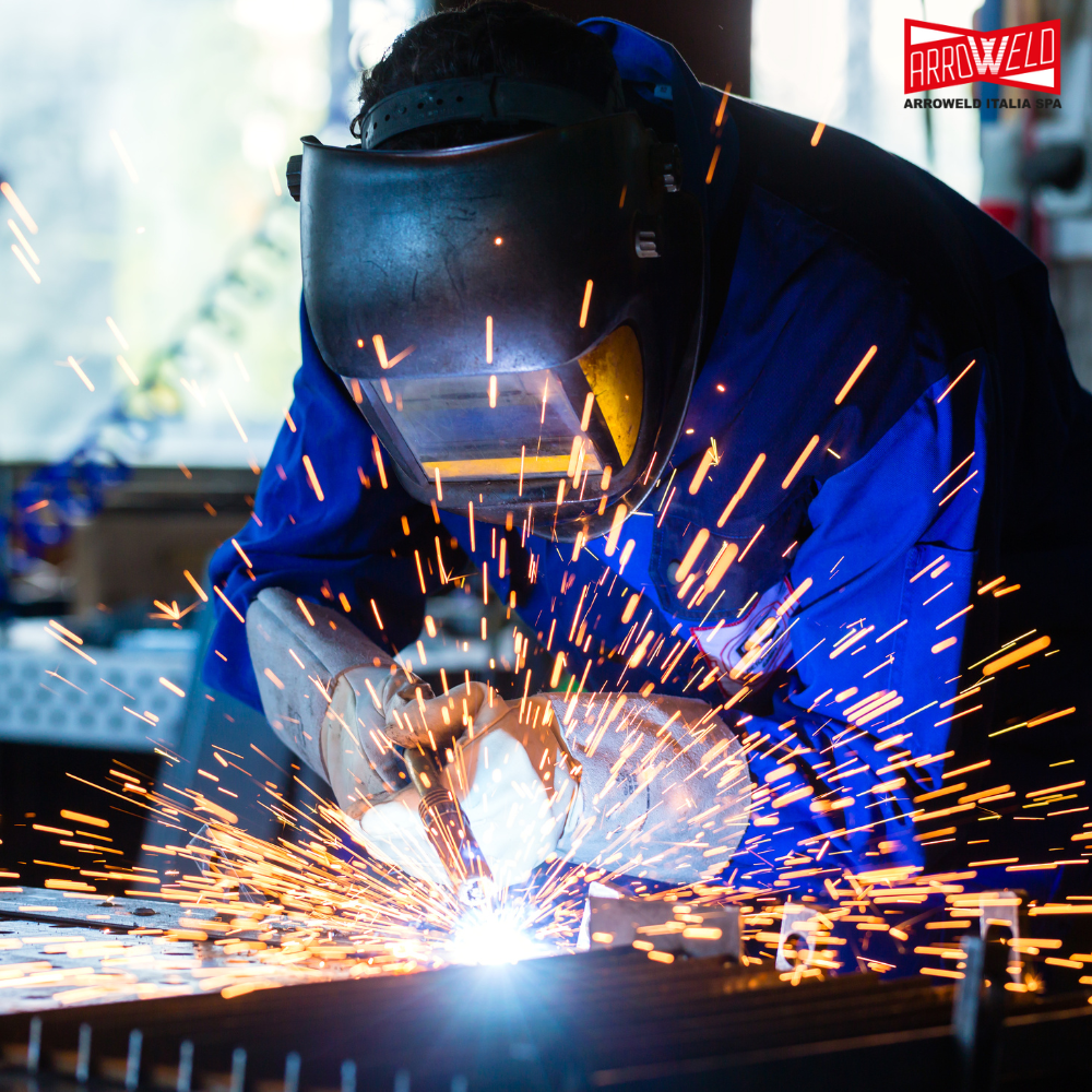 Saldatore professionista che esegue saldatura TIG su acciaio inossidabile con torcia e gas di protezione in officina industriale