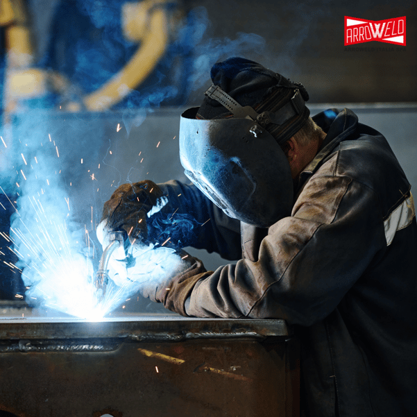 Operatore che esegue saldatura TIG con arco luminoso su metallo.